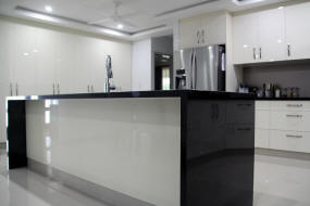 Modern gloss cabinets with black granite bench tops