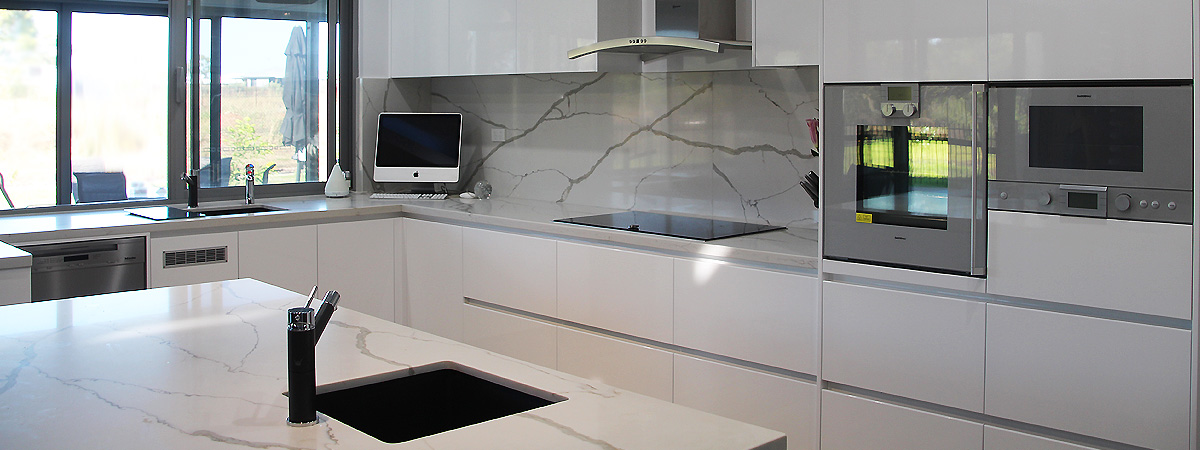 Kitchen island bench with recessed black sink and tap